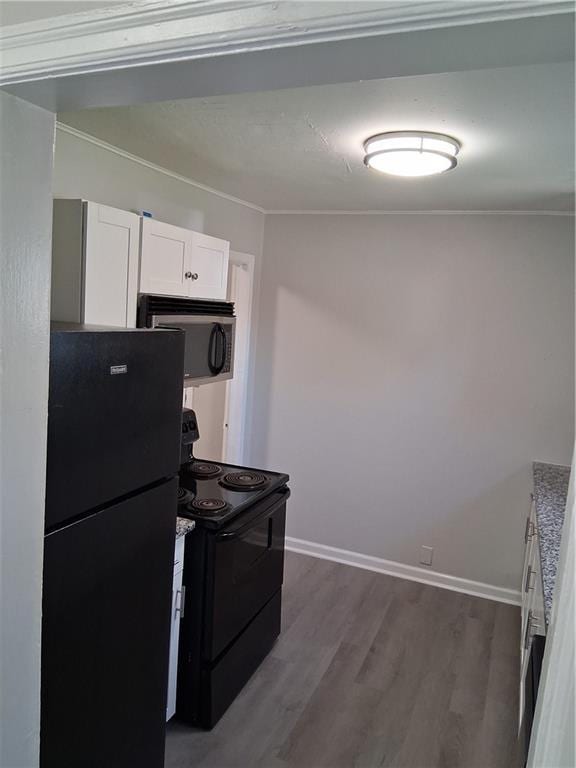 3304 Norton St, Kansas City, MO 64128 - kitchen featuring black appliances, white cabinets, dark wood finished floors, and light countertops