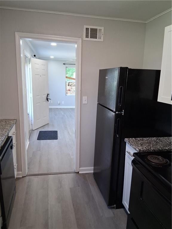 3304 Norton St, Kansas City, MO 64128 - kitchen with black range with electric stovetop, wood finished floors, white cabinets, stone countertops, and crown molding