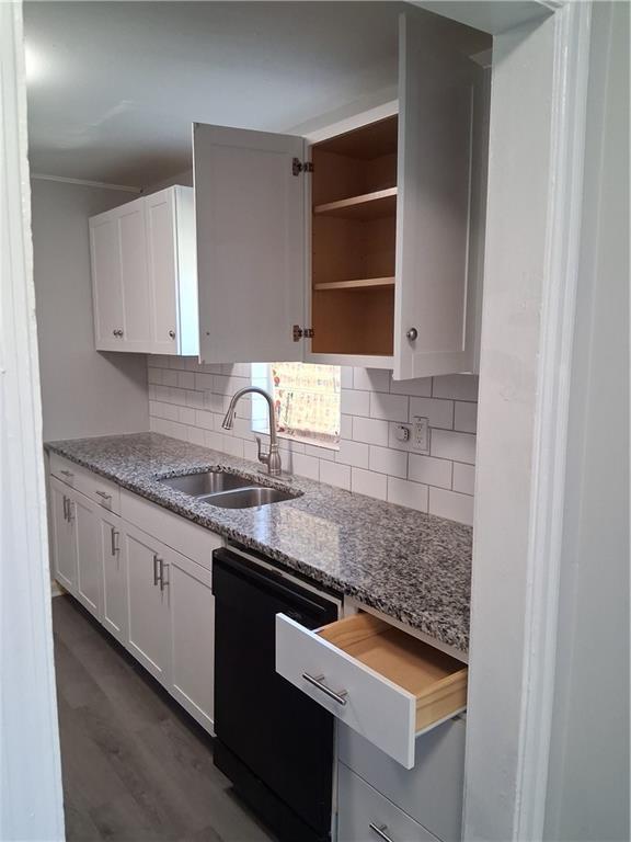 3304 Norton St, Kansas City, MO 64128 - kitchen with dishwasher, decorative backsplash, white cabinetry, and light stone counters