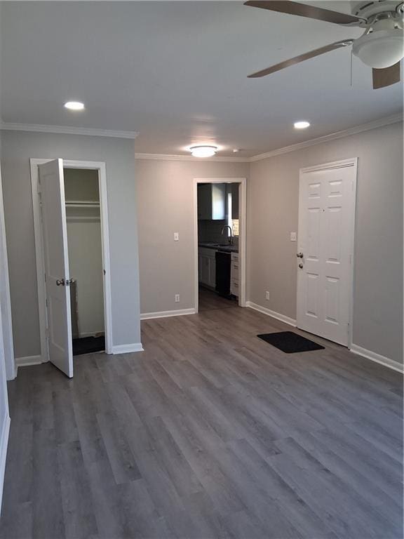 3304 Norton St, Kansas City, MO 64128 - unfurnished living room with a ceiling fan, recessed lighting, crown molding, and dark wood finished floors
