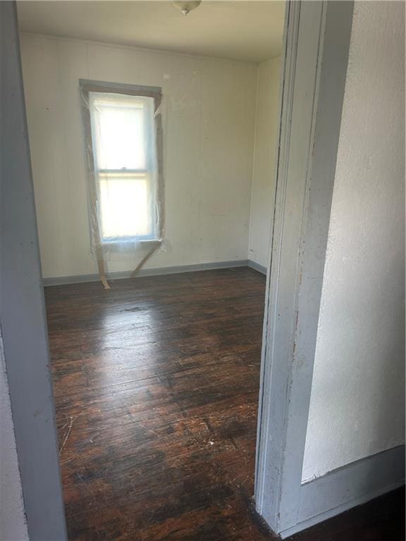 209 S Prairie, Yates Center, KS 66783 - spare room featuring dark wood finished floors and baseboards
