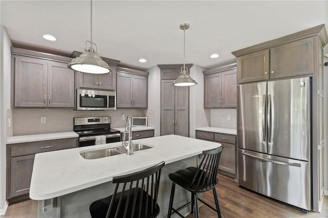 20335 W 220th Ter, Spring Hill, KS 66083 - kitchen featuring appliances with stainless steel finishes, dark wood-style floors, tasteful backsplash, a breakfast bar, and recessed lighting