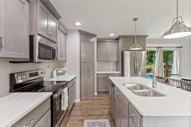 20335 W 220th Ter, Spring Hill, KS 66083 - kitchen featuring stainless steel appliances, dark wood-style floors, a kitchen island with sink, light countertops, and backsplash