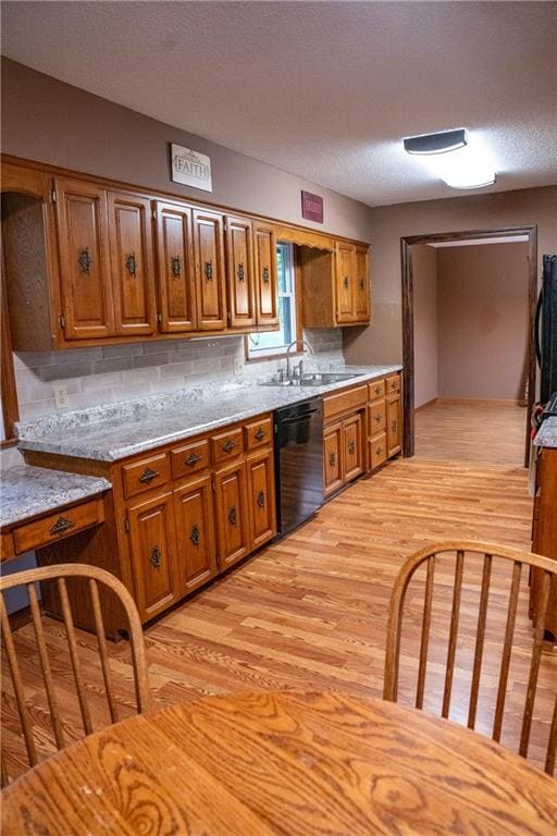 2421 Elephant Trl, Saint Joseph, MO 64506 - kitchen featuring black dishwasher, brown cabinets, light wood-style floors, and a textured ceiling