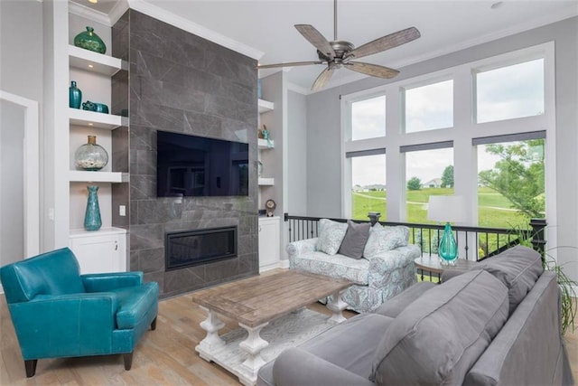 14423 N 145th St, Basehor, KS 66007 - living room with ornamental molding, light wood-style floors, built in features, healthy amount of natural light, and a tiled fireplace