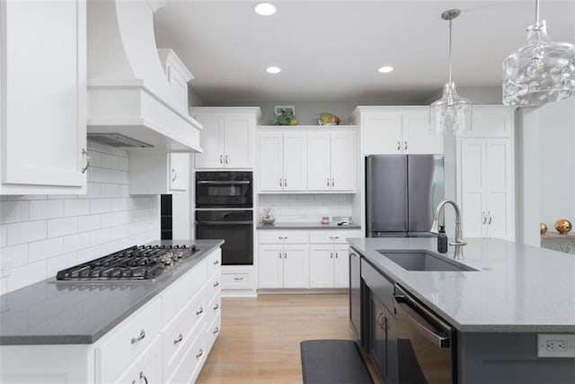 14423 N 145th St, Basehor, KS 66007 - kitchen featuring appliances with stainless steel finishes, custom range hood, a center island with sink, white cabinets, and recessed lighting