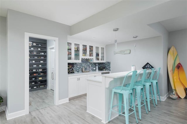 14423 N 145th St, Basehor, KS 66007 - indoor wet bar with light wood-type flooring, backsplash, and decorative light fixtures