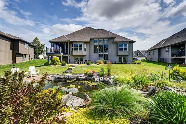14423 N 145th St, Basehor, KS 66007 - rear view of house featuring a lawn, a garden pond, and a balcony