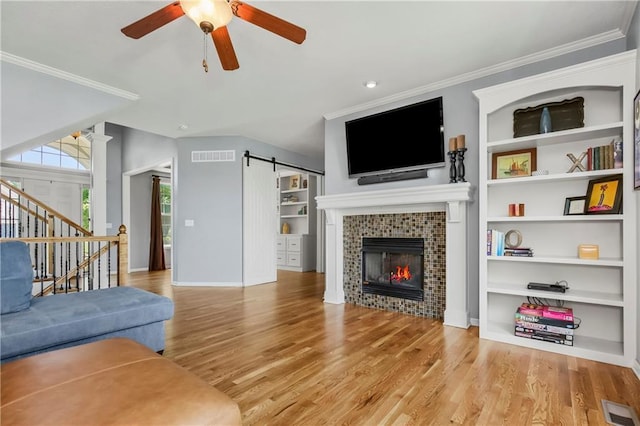 23852 W 124th Ct, Olathe, KS 66061 - living area with wood finished floors, a ceiling fan, a tile fireplace, stairs, and built in features