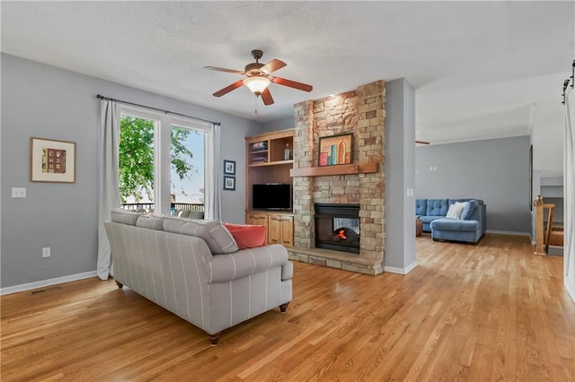 23852 W 124th Ct, Olathe, KS 66061 - living room featuring ceiling fan, light wood finished floors, and a fireplace