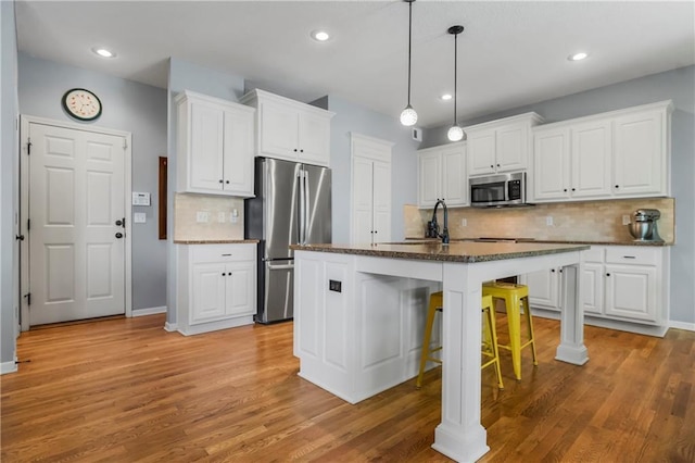 23852 W 124th Ct, Olathe, KS 66061 - kitchen with stainless steel appliances, tasteful backsplash, white cabinetry, a kitchen bar, and recessed lighting