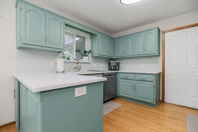 1702 Aspen Ln, Excelsior Springs, MO 64024 - kitchen featuring stainless steel dishwasher, a peninsula, light wood-style flooring, and tasteful backsplash