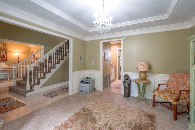 12432 Lamar Ave, Overland Park, KS 66209 - living area with stairway, ornamental molding, a chandelier, a tray ceiling, and wainscoting