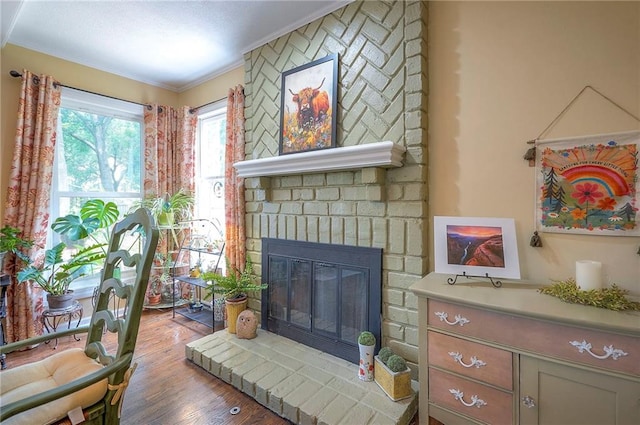 12432 Lamar Ave, Overland Park, KS 66209 - living room featuring a brick fireplace, wood finished floors, and ornamental molding
