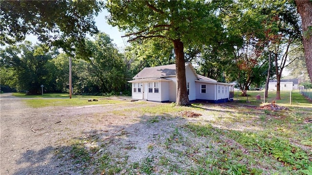 921 E Vine St, Rich Hill, MO 64779 - view of side of home featuring view of wooded area