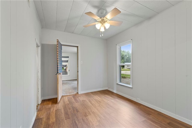 921 E Vine St, Rich Hill, MO 64779 - empty room with wood finished floors and a ceiling fan