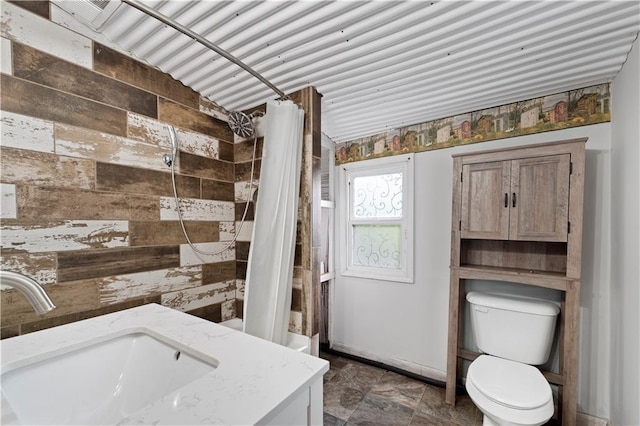 921 E Vine St, Rich Hill, MO 64779 - bathroom with tiled shower, vanity, and stone finish flooring