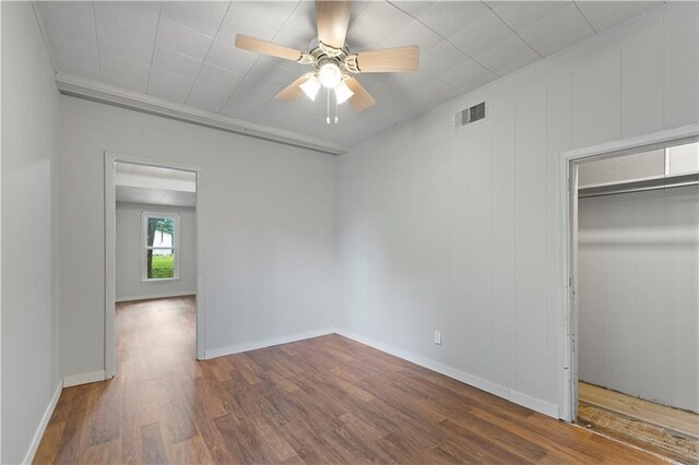 921 E Vine St, Rich Hill, MO 64779 - unfurnished bedroom featuring wood finished floors, ceiling fan, and a closet