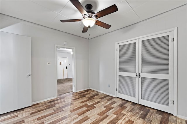 921 E Vine St, Rich Hill, MO 64779 - unfurnished bedroom with wood finished floors, a closet, and ceiling fan