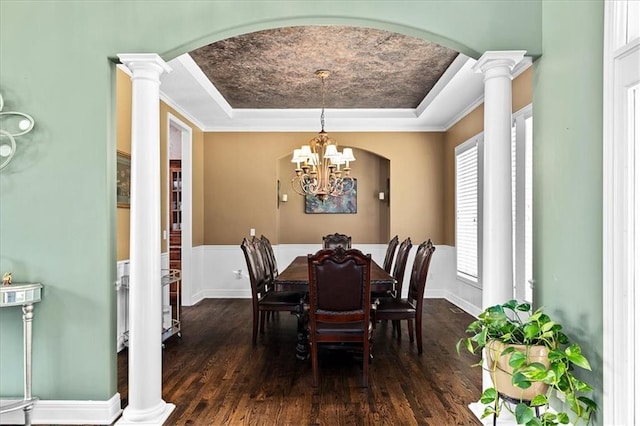 14409 Grandview St, Overland Park, KS 66221 - dining room featuring a raised ceiling, arched walkways, hardwood / wood-style flooring, decorative columns, and a wainscoted wall