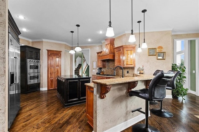 14409 Grandview St, Overland Park, KS 66221 - kitchen featuring appliances with stainless steel finishes, premium range hood, dark wood-type flooring, a peninsula, and a breakfast bar area