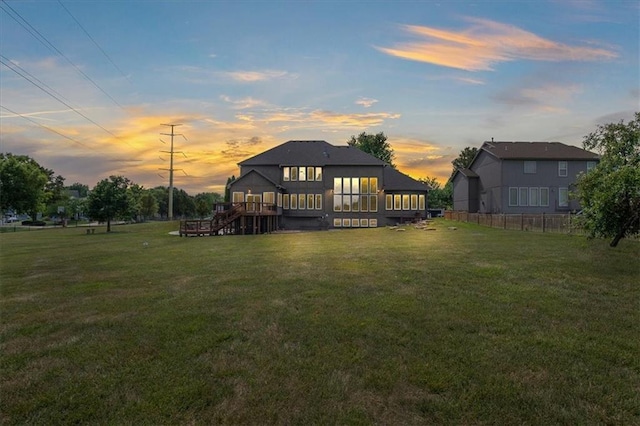14409 Grandview St, Overland Park, KS 66221 - back of property at dusk with a deck, a sunroom, and stairs