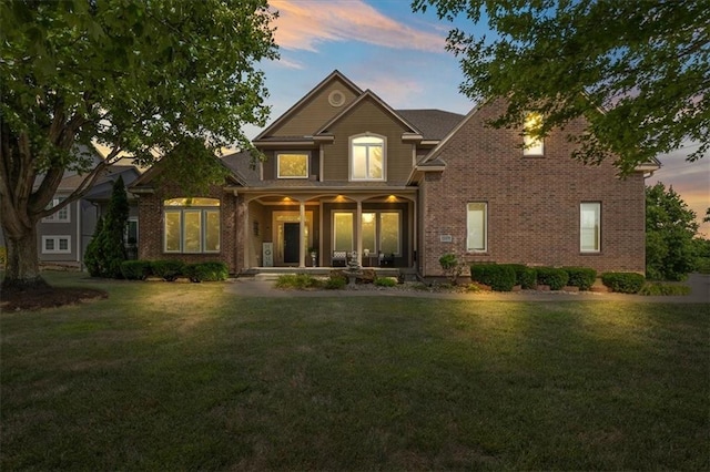 14409 Grandview St, Overland Park, KS 66221 - view of front facade featuring covered porch, a front yard, and brick siding