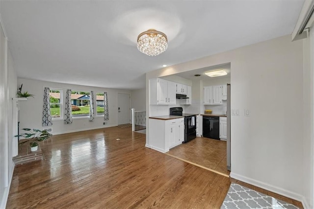 8815 W 81st St, Overland Park, KS 66204 - kitchen with black appliances, open floor plan, a chandelier, white cabinets, and wood finished floors