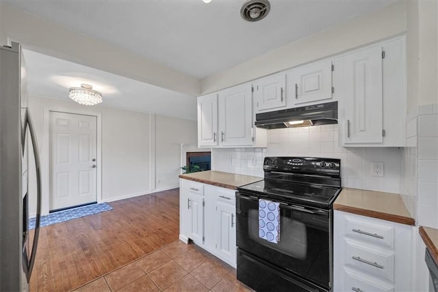 8815 W 81st St, Overland Park, KS 66204 - kitchen featuring black range with electric cooktop, under cabinet range hood, stainless steel fridge, white cabinets, and light tile patterned flooring