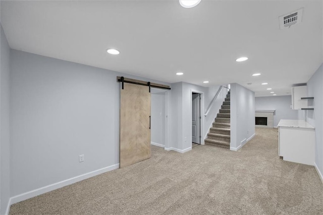 8815 W 81st St, Overland Park, KS 66204 - finished basement with a fireplace, stairs, light carpet, a barn door, and recessed lighting