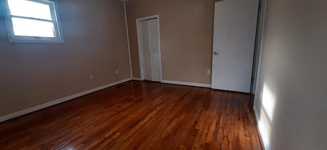615 Church St, Neodesha, KS 66757 - unfurnished bedroom featuring dark wood finished floors and a closet