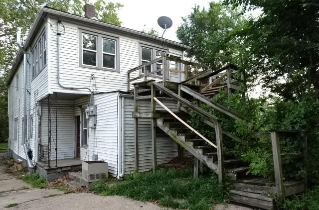 426 Pottawatomie St, Leavenworth, KS 66048 - back of house with a chimney, stairs, and a wooden deck
