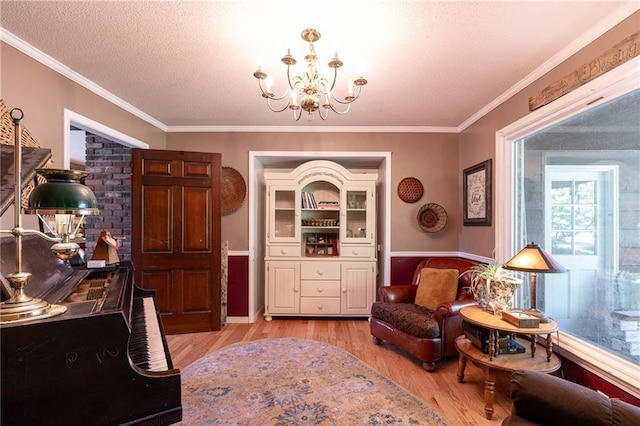 25421 Marel Rd, Excelsior Springs, MO 64024 - sitting room with light wood-style flooring, a chandelier, crown molding, and a textured ceiling