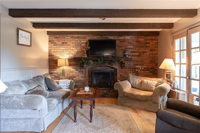 25421 Marel Rd, Excelsior Springs, MO 64024 - living room with wood finished floors, a wainscoted wall, beamed ceiling, and a fireplace