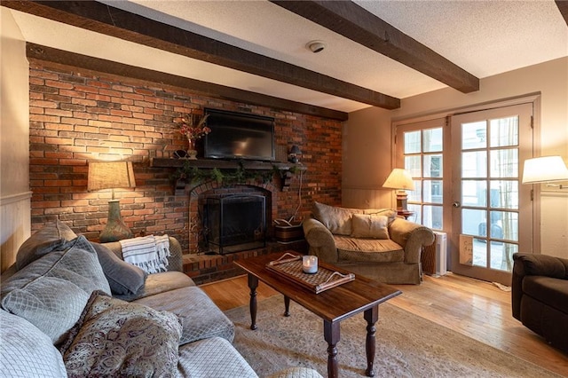 25421 Marel Rd, Excelsior Springs, MO 64024 - living area with beamed ceiling, wood finished floors, a fireplace, and a wainscoted wall