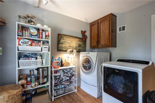 25421 Marel Rd, Excelsior Springs, MO 64024 - laundry area with cabinet space, washing machine and clothes dryer, and wood finished floors
