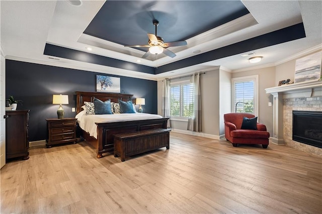 16420 Lucille St, Overland Park, KS 66221 - bedroom with a tray ceiling, crown molding, light wood finished floors, a brick fireplace, and ceiling fan