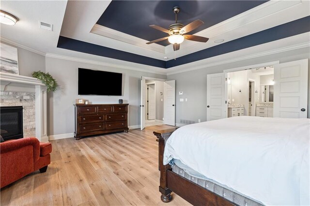 16420 Lucille St, Overland Park, KS 66221 - bedroom with a raised ceiling, ornamental molding, light wood-style floors, a stone fireplace, and ceiling fan