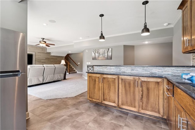 16420 Lucille St, Overland Park, KS 66221 - kitchen featuring freestanding refrigerator, ceiling fan, brown cabinets, decorative light fixtures, and ornamental molding