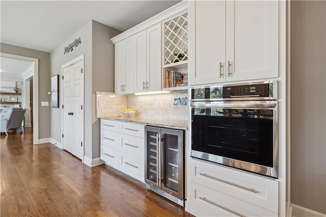 16420 Lucille St, Overland Park, KS 66221 - indoor dry bar featuring wine cooler, stainless steel oven, decorative backsplash, and dark wood finished floors