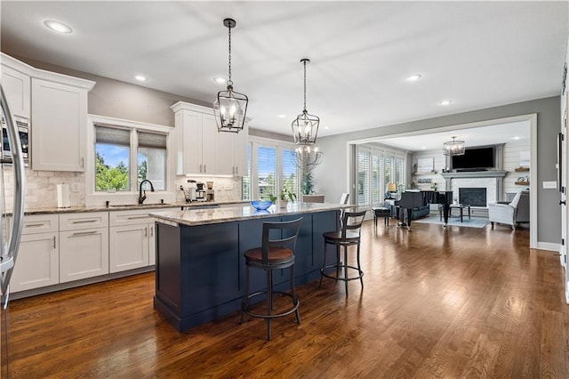 16420 Lucille St, Overland Park, KS 66221 - kitchen with white cabinetry, light stone countertops, a kitchen island, healthy amount of natural light, and recessed lighting