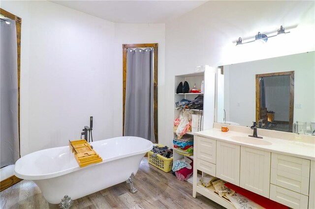 600 W Chestnut St, Holden, MO 64040 - full bath with wood finished floors, vanity, and a soaking tub