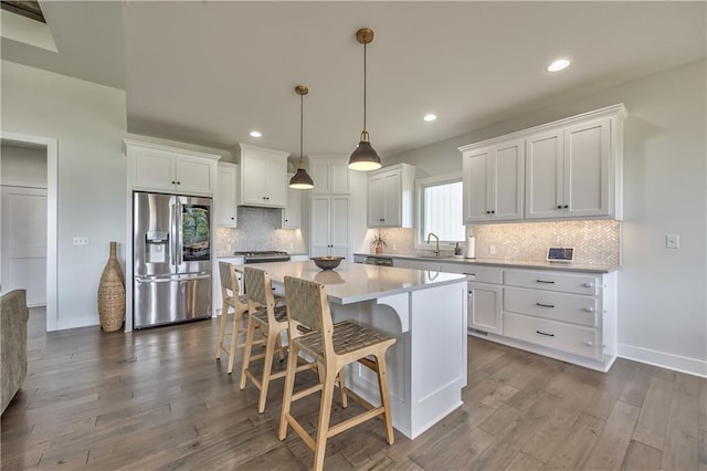 24976 W 87th St, Lenexa, KS 66227 - kitchen with stainless steel refrigerator with ice dispenser, a center island, white cabinets, a breakfast bar area, and tasteful backsplash