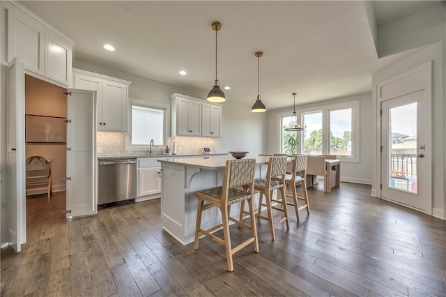24976 W 87th St, Lenexa, KS 66227 - kitchen with dishwasher, a kitchen island, white cabinets, decorative backsplash, and a breakfast bar