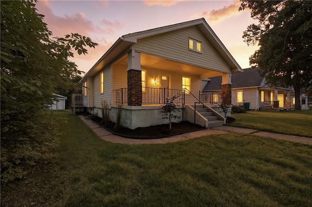 1962 N 28th St, Kansas City, KS 66104 - view of front facade featuring covered porch, a front yard, and stone siding
