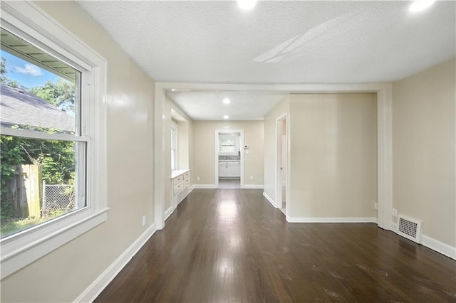 1962 N 28th St, Kansas City, KS 66104 - corridor featuring dark wood-type flooring, healthy amount of natural light, and a textured ceiling