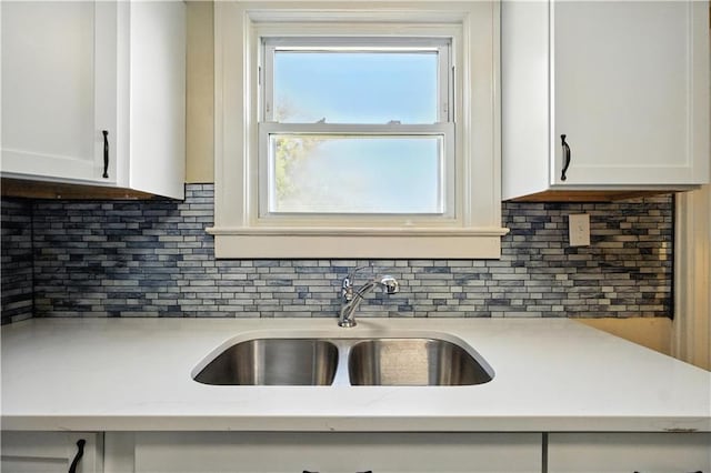1962 N 28th St, Kansas City, KS 66104 - kitchen with white cabinetry, backsplash, and light stone countertops
