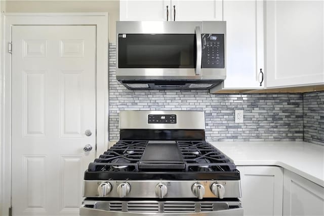 1962 N 28th St, Kansas City, KS 66104 - kitchen with stainless steel appliances, backsplash, white cabinetry, and light countertops