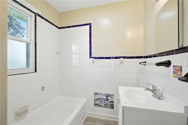 1962 N 28th St, Kansas City, KS 66104 - bathroom with a bath, vanity, wood finished floors, and tile walls