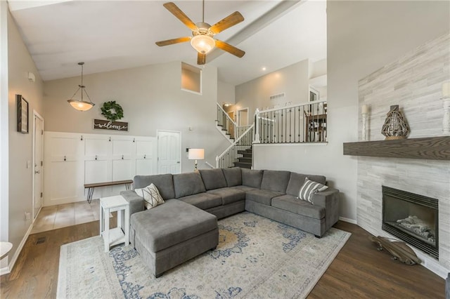 8103 NE 111th Ter, Kansas City, MO 64157 - living area with high vaulted ceiling, a ceiling fan, wood finished floors, stairs, and a tiled fireplace